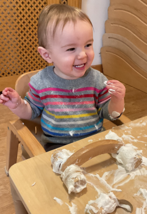 Happy baby discovering a fun foam activity at Whitstable Day Nursery